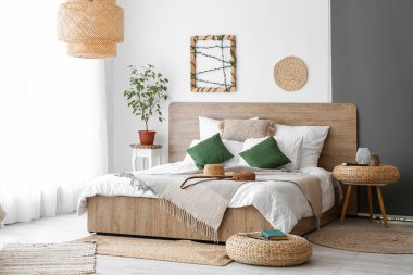 Interior of cozy bedroom with rattan poufs and accessories