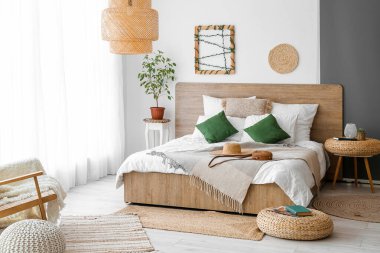 Interior of cozy bedroom with rattan poufs and accessories
