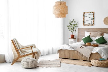 Interior of cozy bedroom with poufs and armchair