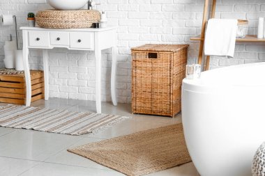 Rattan laundry basket in interior of cozy bathroom