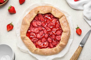 Tasty strawberry galette on light background