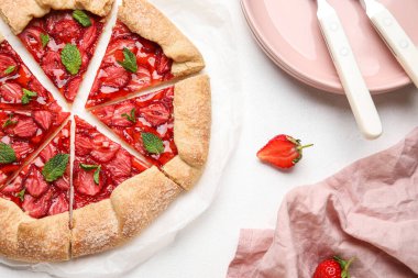 Cut strawberry galette on light background, closeup