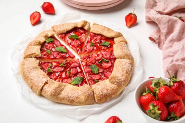Cut strawberry galette on light background