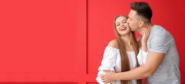 Young Man Kissing His Girlfriend Red Background Space Text — Stok fotoğraf