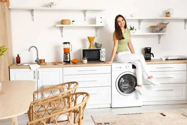 Young Woman Sitting Washing Machine Kitchen — стоковое фото