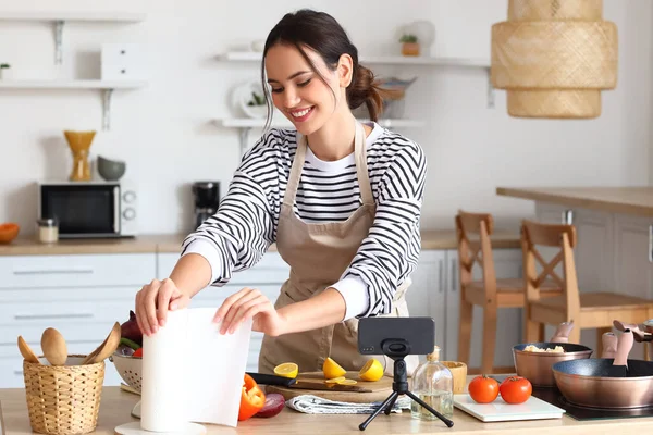 Young Woman Taking Paper Towel While Cooking Video Tutorial Kitchen — Stok fotoğraf