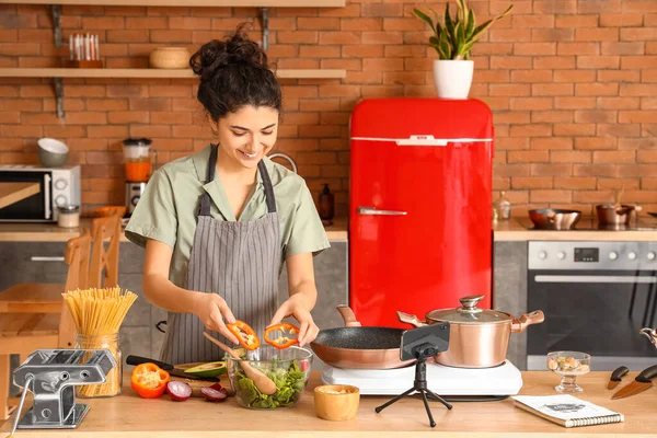 Young Woman Putting Bell Pepper Bowl While Video Tutorial Kitchen — Stok fotoğraf