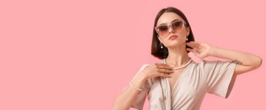 Portrait of pretty woman wearing stylish eyeglasses and jewelry on pink background with space for text