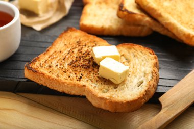 Slice of toasted bread with butter on table, closeup