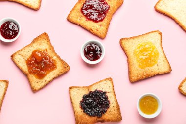 Delicious toasts and bowls of jam on pink background