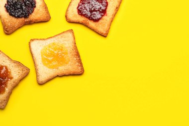 Toasts with sweet jams on yellow background