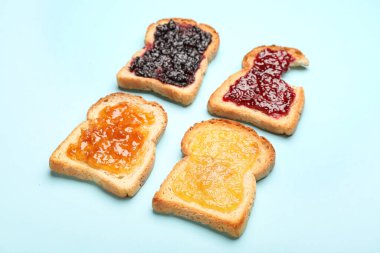 Toasts with different jams on color background