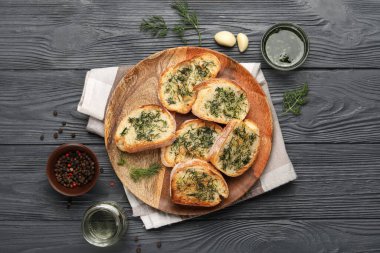 Composition with slices of toasted garlic bread, spices and oil on dark wooden background