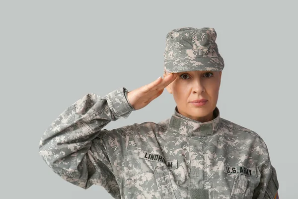 Mature Female Soldier Saluting Grey Background — Stok Foto