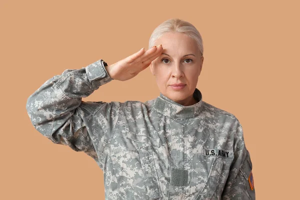 Mature Female Soldier Saluting Beige Background — Stock Photo, Image