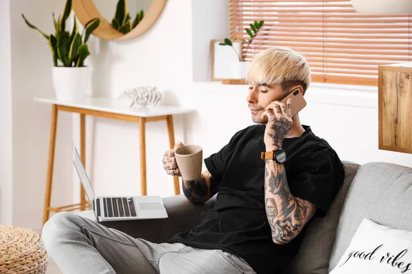 Young Tattooed Man Cup Coffee Laptop Talking Mobile Phone Home — Foto de Stock