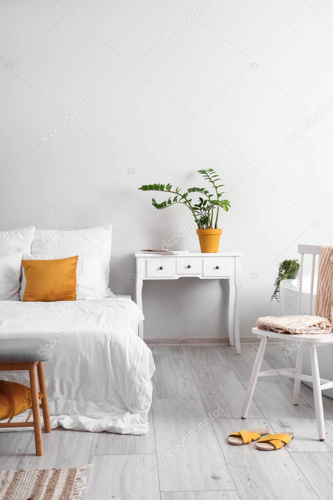 Interior of light bedroom with table and chair