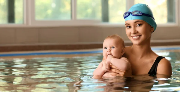 Swimming coach and adorable little baby in pool