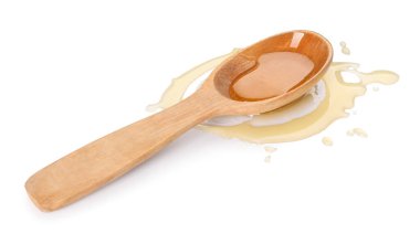 Wooden spoon with tasty maple syrup on white background