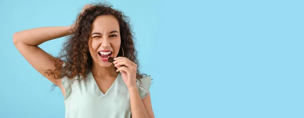 Beautiful Young African American Woman Eating Delicious Chocolate Candy Blue — Stock Photo, Image