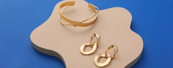 Stylish Golden Bracelet Earrings Blue Background — Stock fotografie