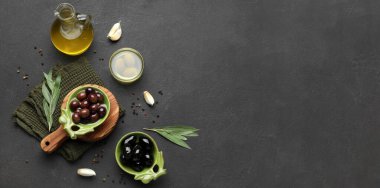 Composition with fresh oil and olives on dark background with space for text