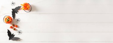 Composition with tasty Halloween treats on white wooden background with space for text