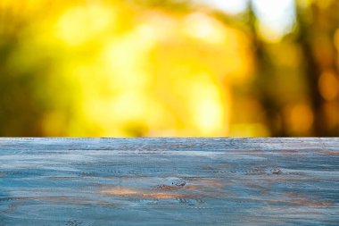Empty blue wooden table in autumn park