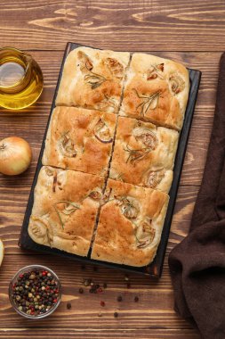 Board with tasty Italian focaccia on wooden table