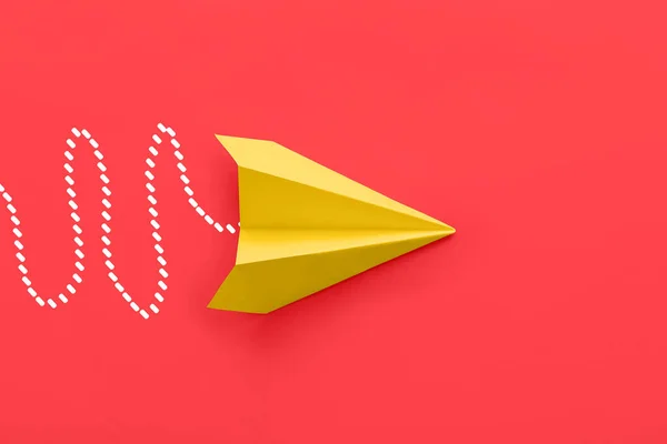 Paper plane on red background, top view