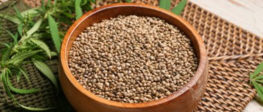 Bowl with healthy hemp seeds on table, closeup