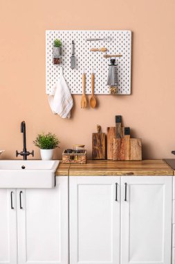 kitchen counters with sink and utensils near beige wall