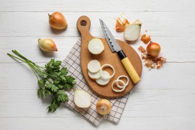 Composition with fresh onion and parsley on light wooden background