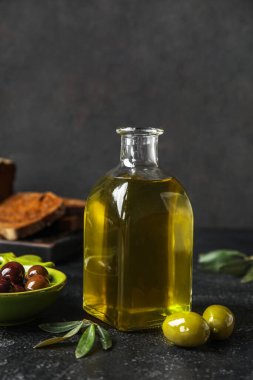 Bottle of fresh olive oil on dark background