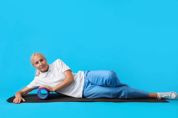 Mature Physiotherapist Training Foam Roller Blue Background — Stock Photo, Image