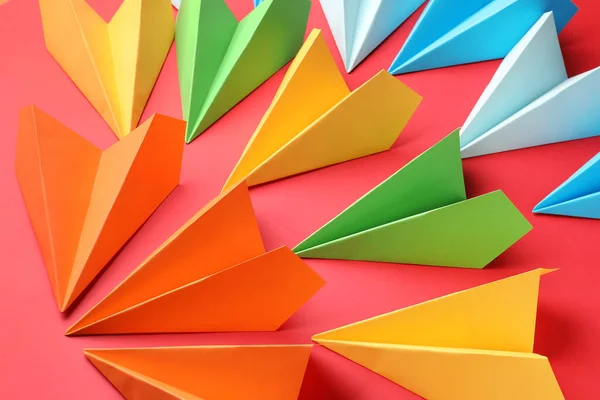 Colorful paper planes on red background