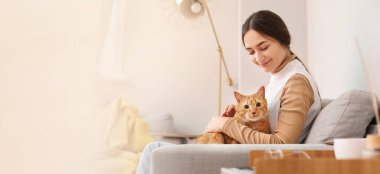 Woman with cute red cat sitting on sofa. Banner for design