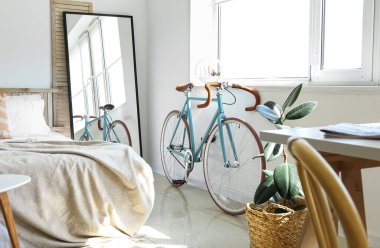 Modern bicycle near window in light bedroom