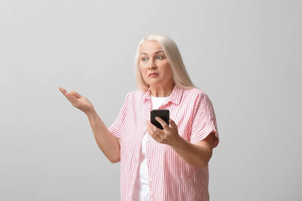 Upset Mature Woman Mobile Phone Navigation Light Background — Foto Stock