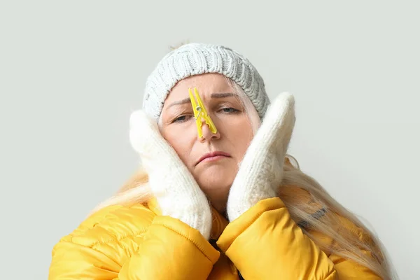 Ill Mature Woman Clothespin Light Background Closeup Stuffy Nose Concept — Stockfoto