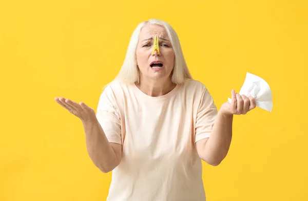 Stressed Mature Woman Clothespin Tissue Yellow Background Stuffy Nose Concept — 图库照片
