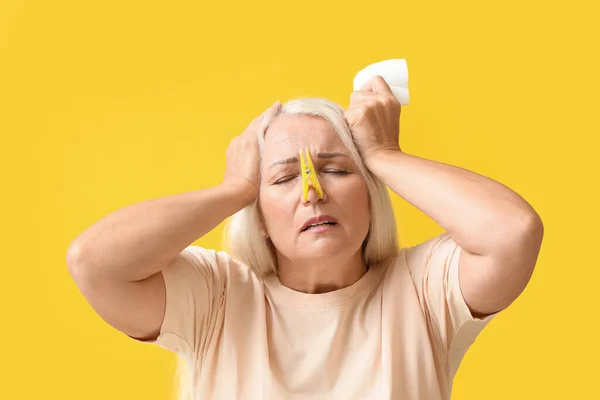 Ill Mature Woman Clothespin Tissue Yellow Background Stuffy Nose Concept — Zdjęcie stockowe