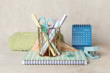 Pen cup with school stationery on light background