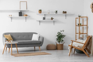 Interior of cozy living room with sofa, shelves and houseplants