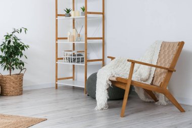 Interior of cozy living room with armchair and shelving unit