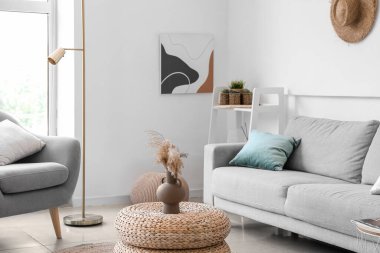 Interior of cozy living room with rattan poufs and sofa