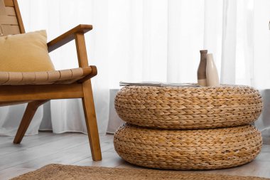Rattan poufs with vases and magazine near light curtain