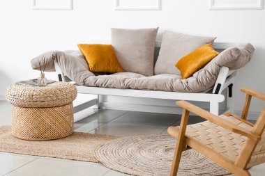 Interior of cozy living room with rattan poufs and couch