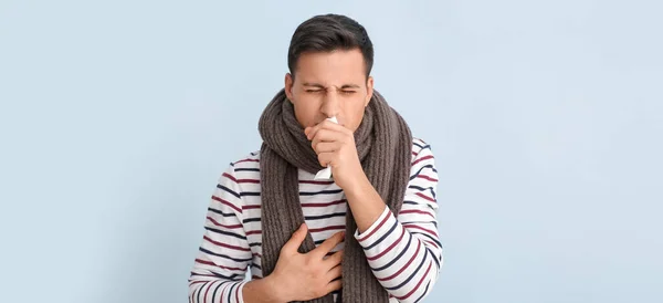 Coughing young man on light background