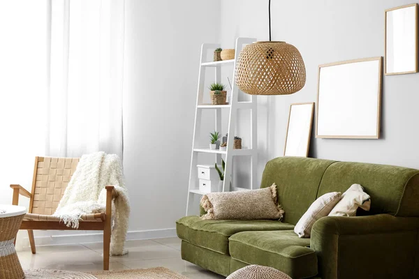 Interior of cozy living room with green sofa and armchair